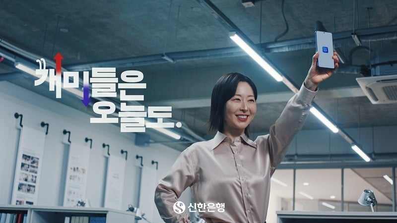 여자가 휴대폰 든 손을 번쩍 들고있는 모습
