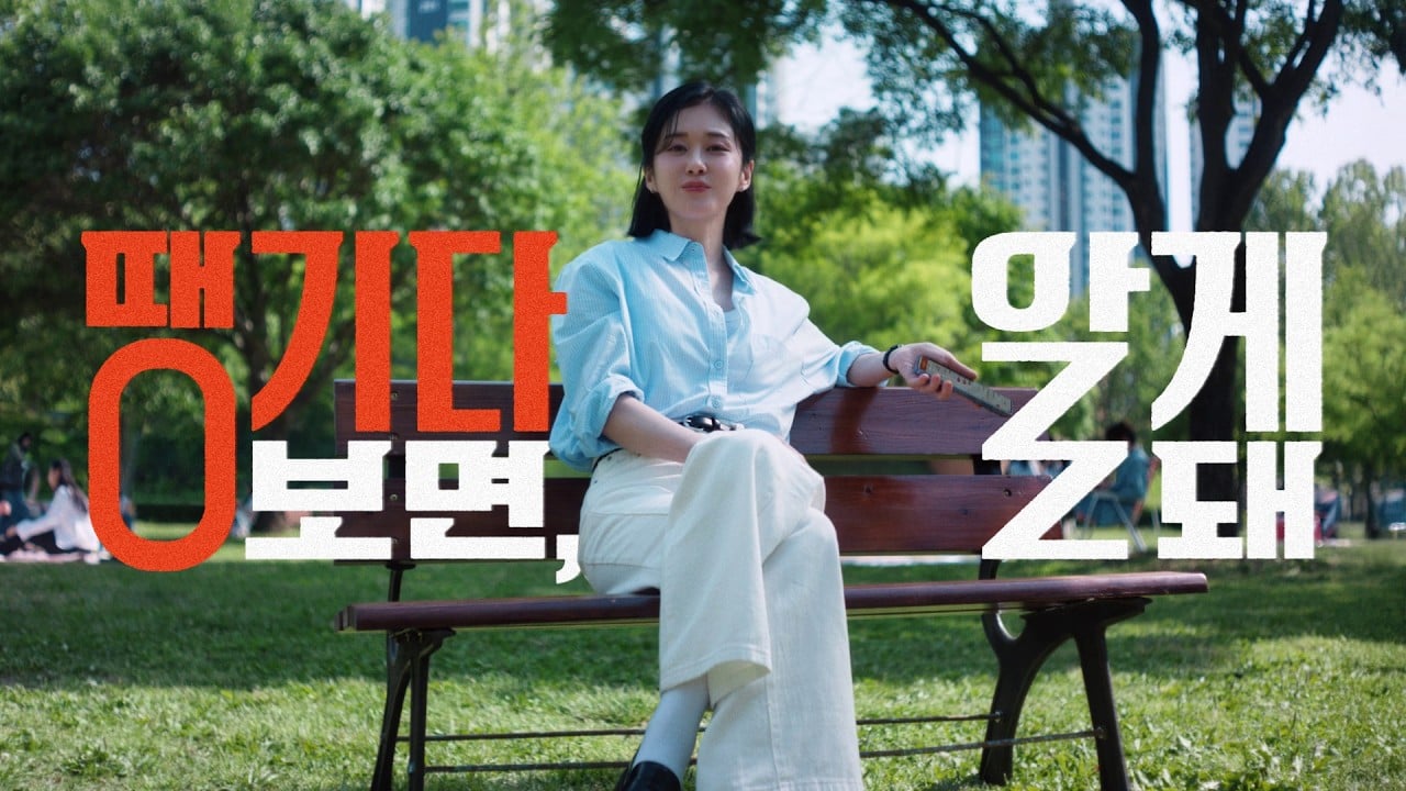 여자가 벤치 앉아서 정면으로 쳐다보고있는 모습